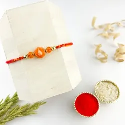 Kalash Pattern Rakhi n Transparent Orange Beads